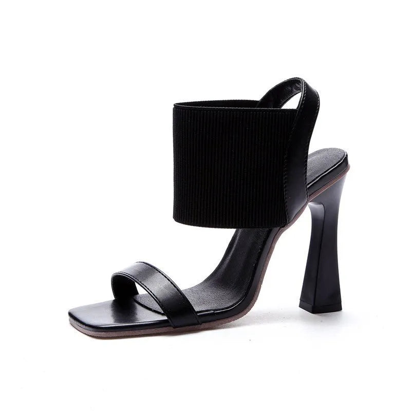 Black high heel sandals for women with criss-cross elastic straps and a rubber sole.