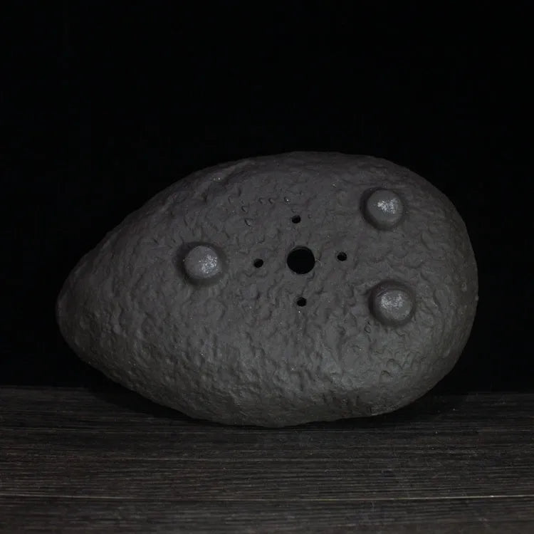 Handmade purple clay flower pot with unique shape showing natural ceramic texture