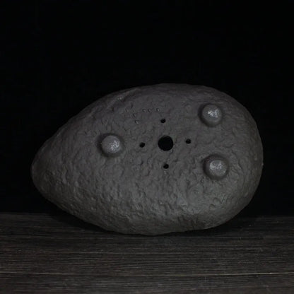 Handmade purple clay flower pot with unique shape showing natural ceramic texture