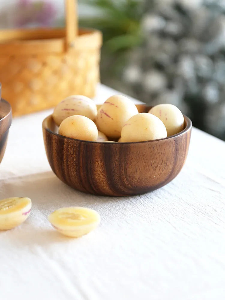 Brown handmade wooden serving bowl with natural wood grain on a table.