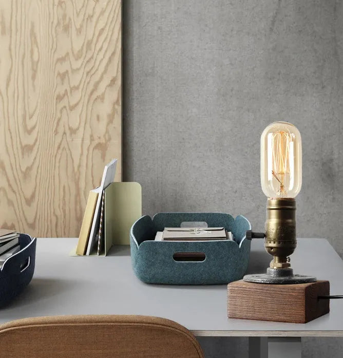 Compact wooden and iron water pipe table lamp on a table.