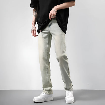 Khaki vintage washed straight-leg jeans with yellow mud dye and letter print, non-stretch mid-rise denim trousers.