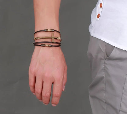 A handcrafted leather bracelet featuring a cross design, perfect for adding a touch of rustic style to any outfit.