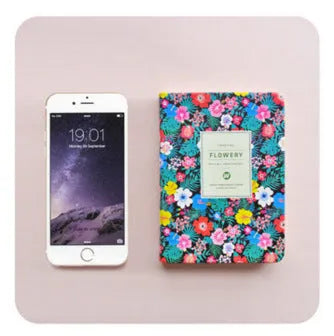 Bo Shide floral notepad with fabric-imitation leather cover in green, shown open on a desk.
