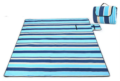 Folding Suede Picnic Moisture-proof Mat in blue stripes, unfolded on grass