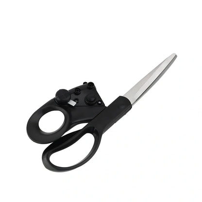 Black laser-guided scissors with red beam cutting straight line on wrapping paper