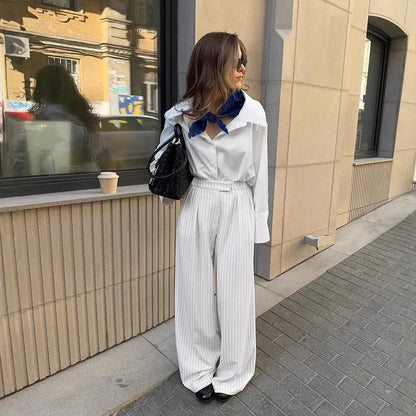 White striped wide-leg casual trousers with a front zipper on a hanger.