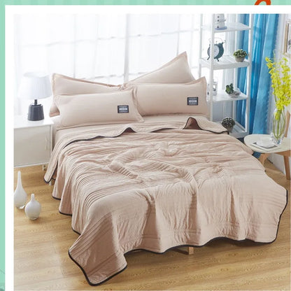 Lightweight plain coloured polyester summer quilt on a bed