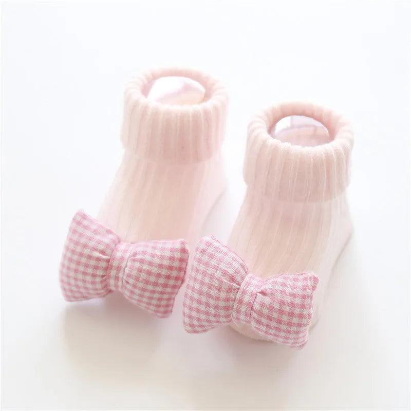 Cotton baby floor socks in assorted colours and patterns including bows, stars, and animal designs.