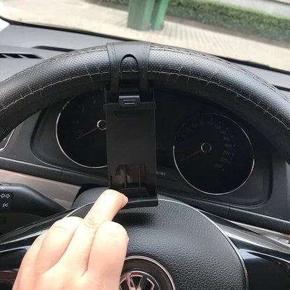 Black steering wheel phone holder with 75mm clip mounted on car wheel holding smartphone