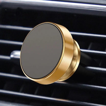 Black magnetic car phone holder with 360-degree ball joint mounted on a car air vent, holding a smartphone.