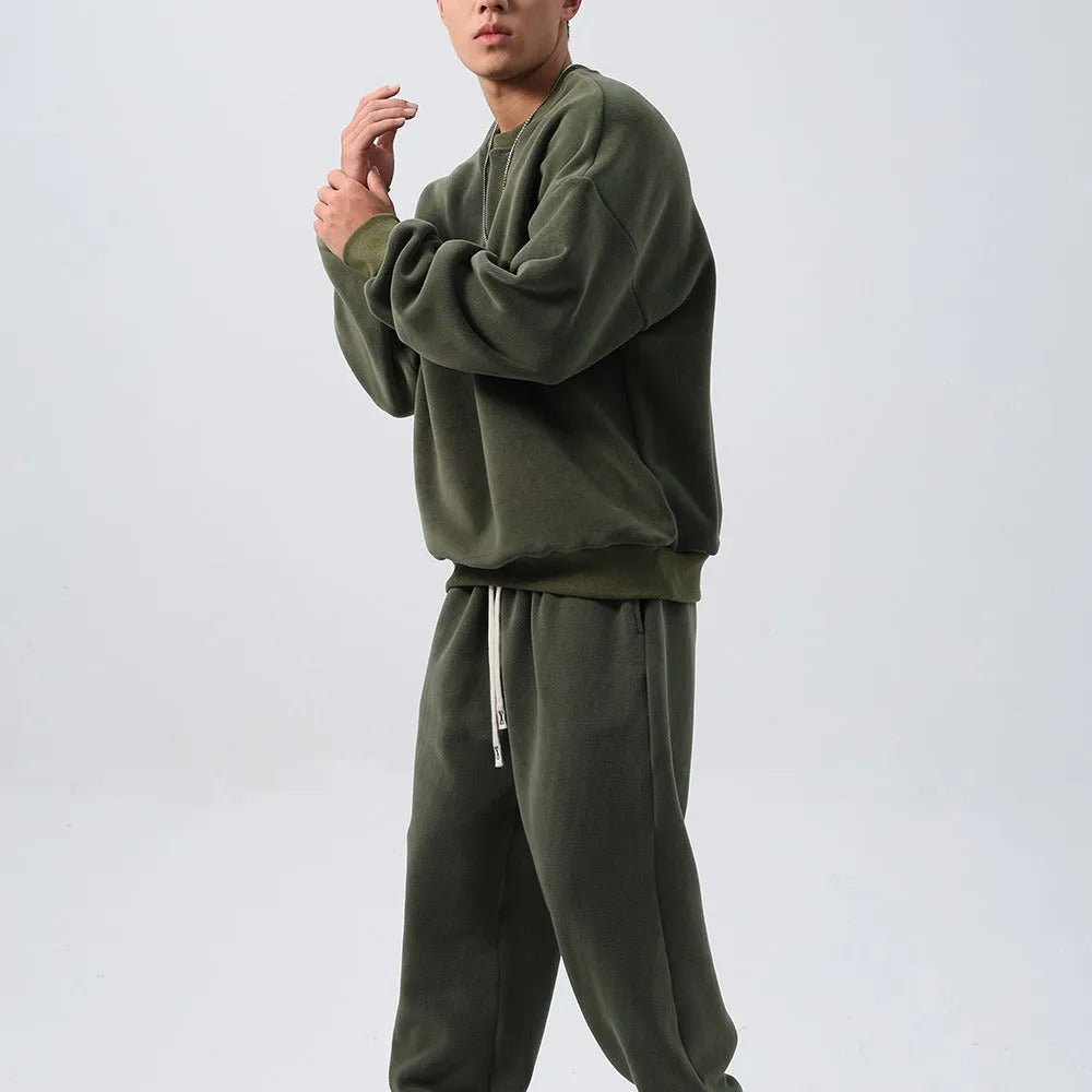 Man wearing a two-piece army green polar fleece suit with crew neck top and padded trousers.