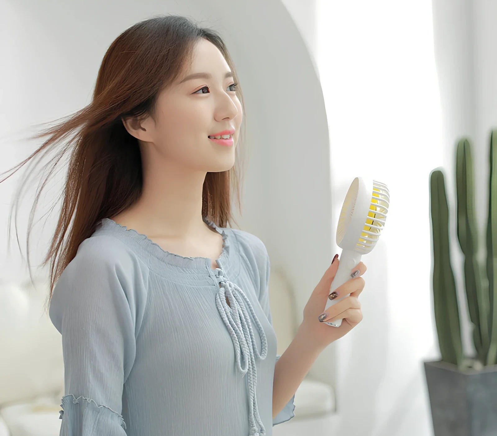 Blue shaking head handheld fan showing oscillating mechanism and USB charging port
