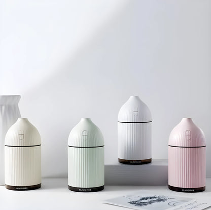 White USB-powered ultrasonic aromatherapy diffuser and humidifier with 300ml bottle and LED light on a desk.