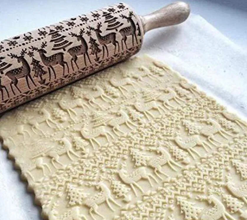 Wooden rolling pin with engraved Christmas patterns including reindeer and snowflakes on a 45cm long barrel.