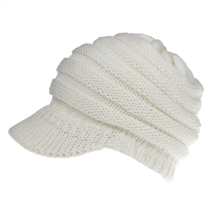 Woman wearing a light grey knitted ponytail beanie with her ponytail pulled through the hole in the back.