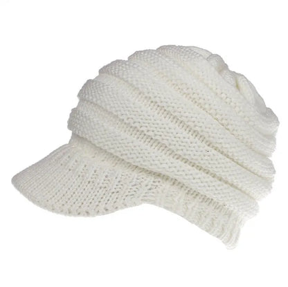Woman wearing a light grey knitted ponytail beanie with her ponytail pulled through the hole in the back.