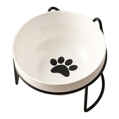 White ceramic pet bowl with cat paw design on a black iron frame raised feeder.