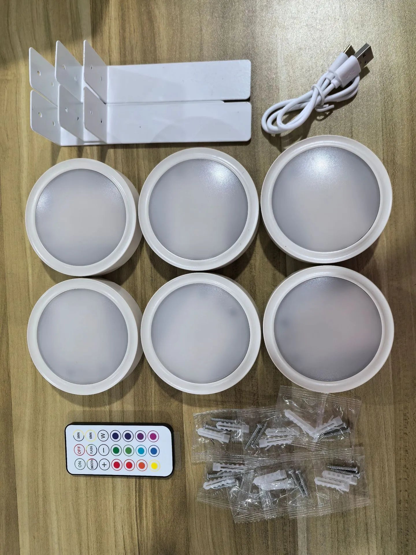 Black magnetic LED painting lamp with remote control on a white wall.