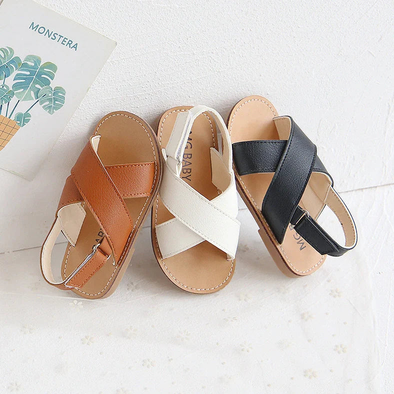 Children's black cross-strap sandals with adjustable Velcro fastening showing size range 21-30