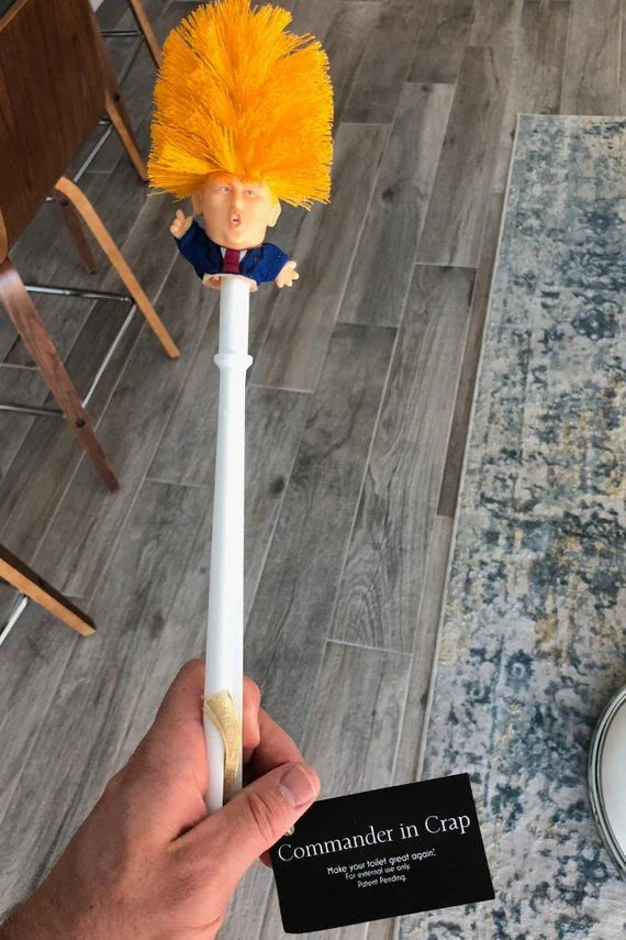Comical Donald Trump-themed toilet brush made of durable plastic with a bold yellow color and convenient hanging slot
