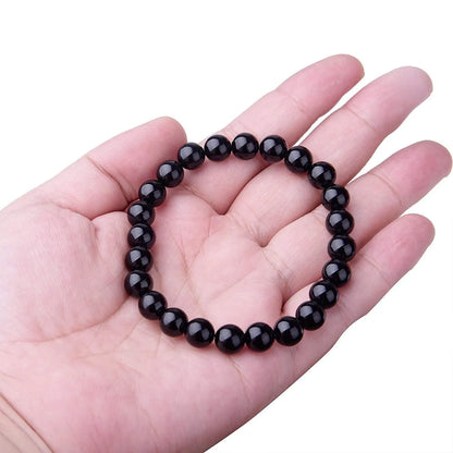 Geometric black agate bracelet for women with 8mm beads on a black elastic cord.