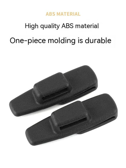 Two black ABS plastic car seat belt stopper clips on a clear OPP bag.