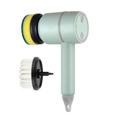 Green electric cleaning brush with scouring pad and brush heads on a kitchen worktop.