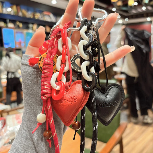 Brown leather heart-shaped gourd pendant keychain with woven rope attached to metal keys