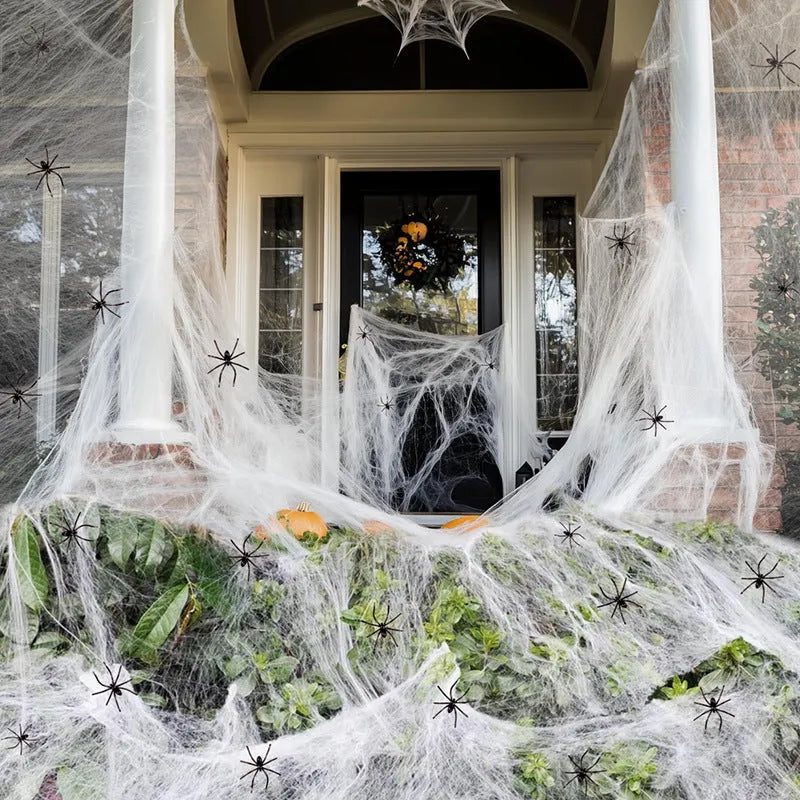 White cotton spider web Halloween decoration with multiple spiders draped over furniture for spooky atmospheric display