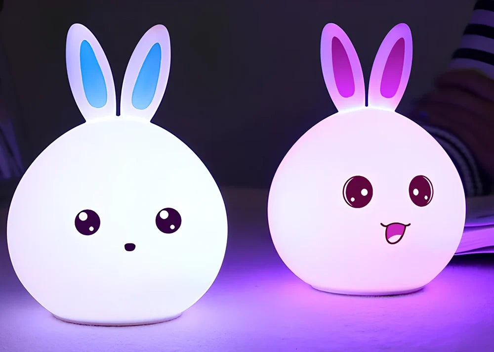 White silicone rabbit night light with USB charging cable showing touch sensor area and colourful LED illumination