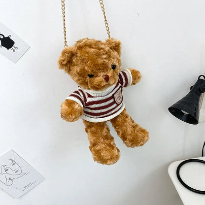 A plush teddy bear crossbody messenger bag with an adjustable shoulder strap and a zippered interior pocket for convenient storage.