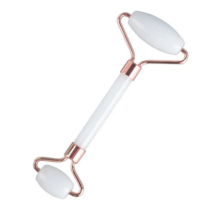 White jade facial roller with double heads and matching scraping board on dark surface