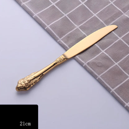 Four-piece stainless steel cutlery set showing main knife, fork, spoon, and teaspoon with mirror finish