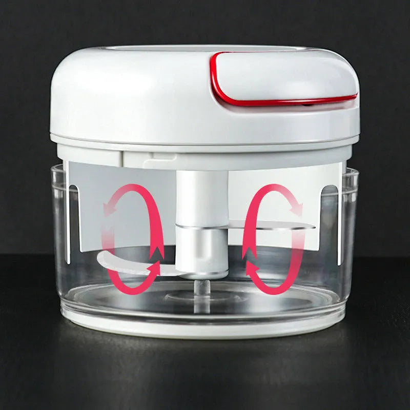 White manual food chopper with stainless steel blades on a kitchen countertop.