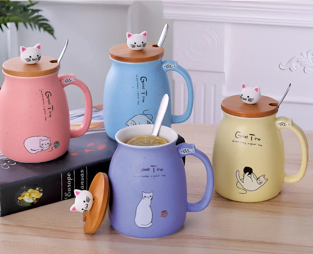 Pink ceramic mug with cartoon cat design, wooden lid, and stainless steel spoon on table