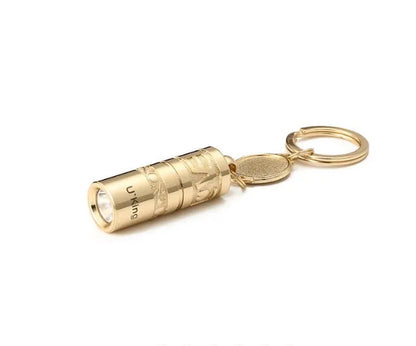 Gold-coloured waterproof zinc alloy mini LED flashlight on a keyring.