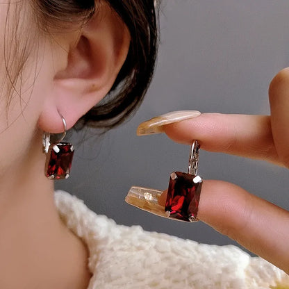 Women's square crystal earrings in copper with purple, red, and yellow colour options measuring 25mm by 10mm.