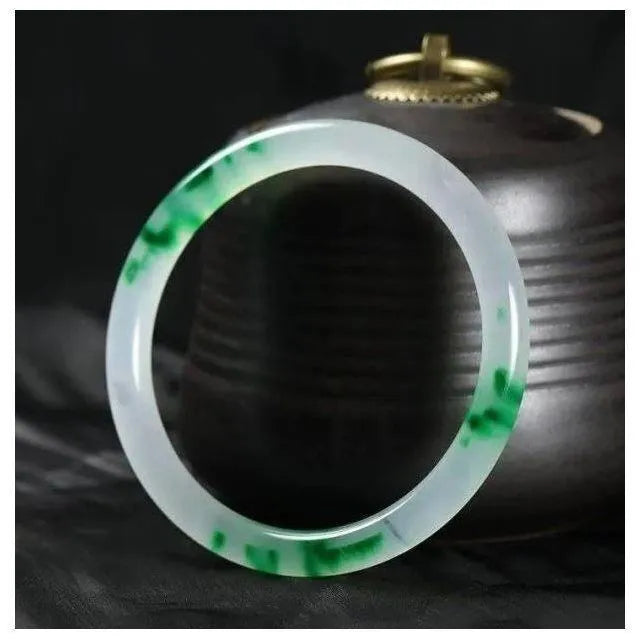 Jade bracelet with floating flower patterns and auspicious cloud motifs in green stone with polished finish