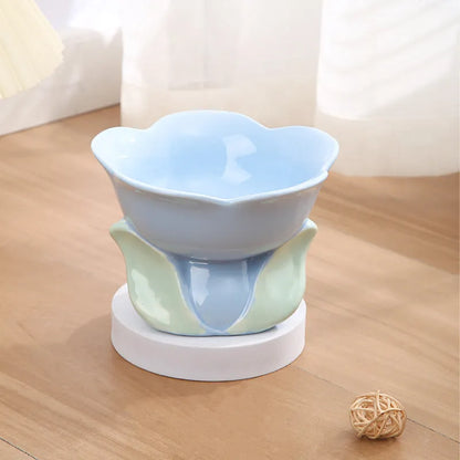 Blue ceramic raised pet bowl with floral pattern and non-slip base for cats or small dogs.