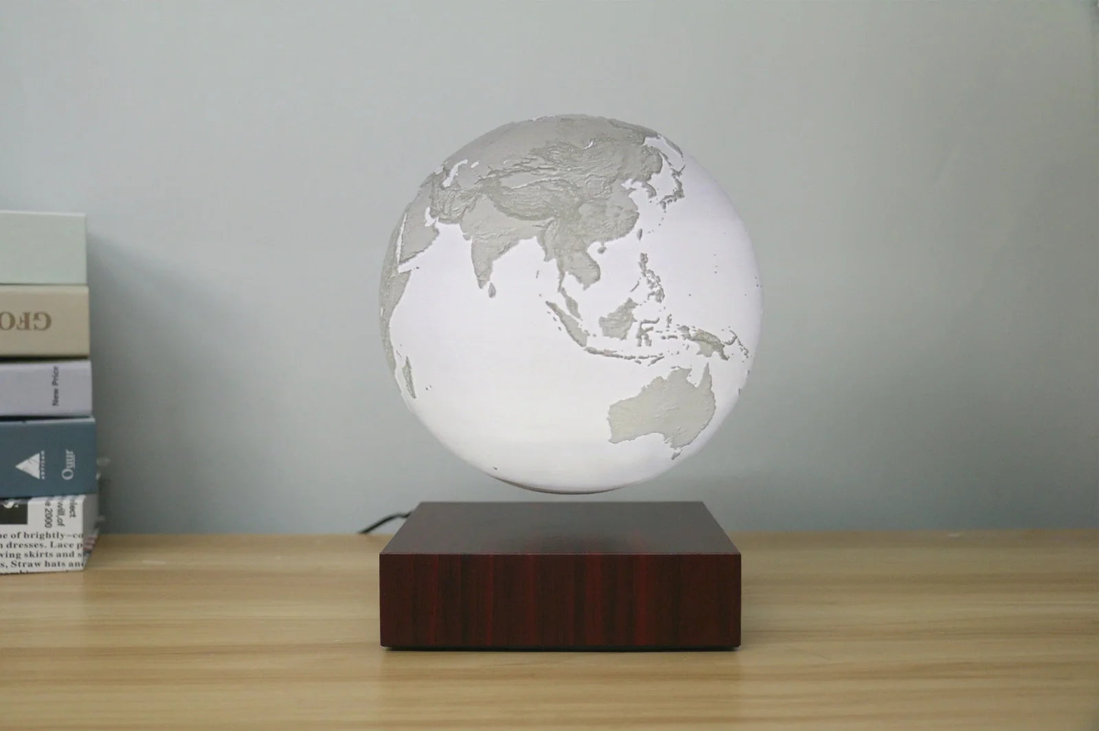 Levitating Earth or Jupiter lamp floating above base with LED illumination