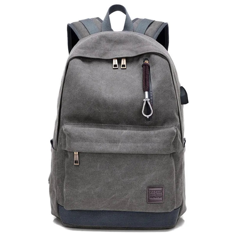 Coffee-coloured canvas backpack with USB charging port on side strap and front zipper pocket.