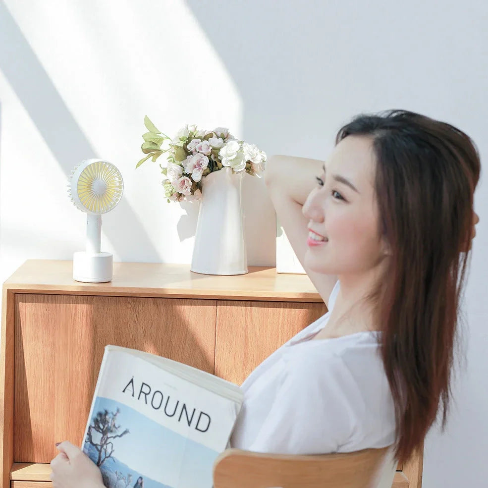 Blue shaking head handheld fan showing oscillating mechanism and USB charging port