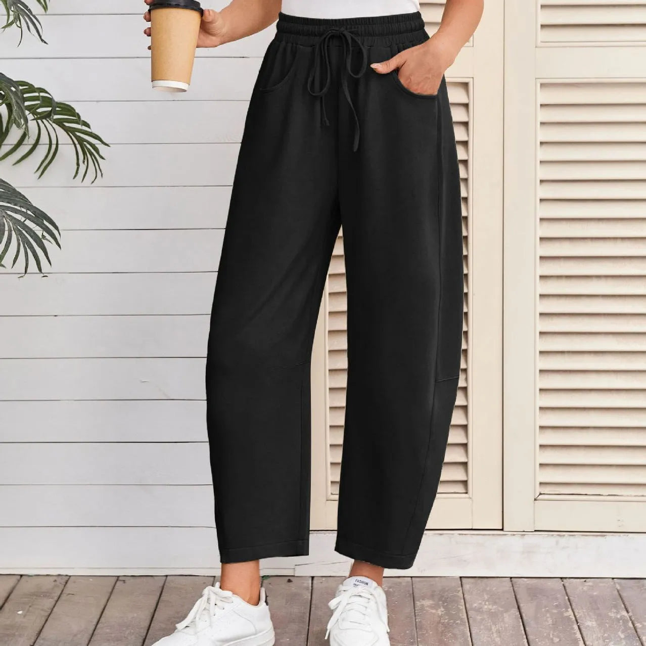 Loose-fit cropped sweatpants in army green with a drawstring waistband and side pockets on a neutral background
