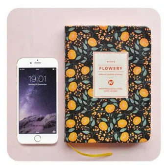 Bo Shide floral notepad with fabric-imitation leather cover in green, shown open on a desk.