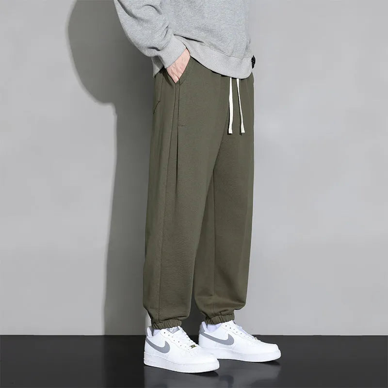 Men's loose gray casual sports trousers with drawstring waist on a hanger