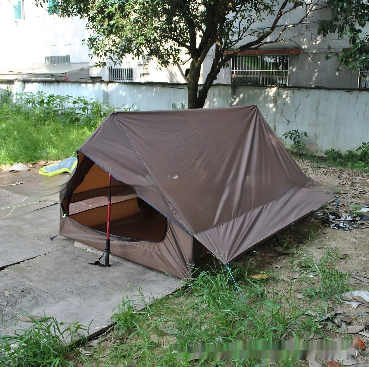 Brown and white portable A-line camping tent set up with hiking poles, showing its spacious interior for 2-3 people.