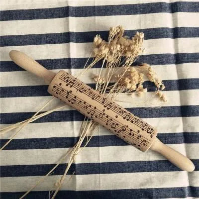 Wooden rolling pin with engraved Christmas patterns including reindeer and snowflakes on a 45cm long barrel.