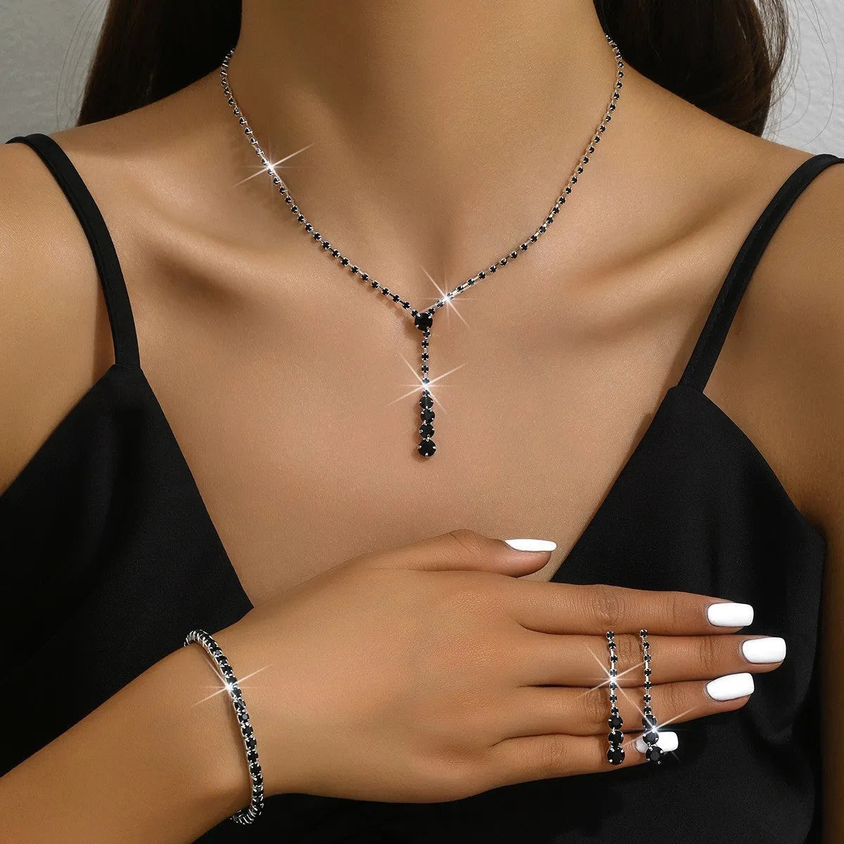 Women's silver pink rhinestone heart tassel earrings, necklace, and bracelet jewellery set on a white background.