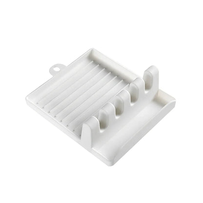 Green silicone spatula holder with four slots for kitchen utensils on countertop